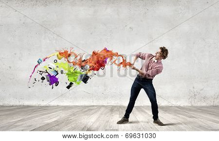 Young man in casual evading from flying icons