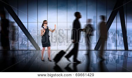 Redhead businesswoman in a blindfold against room with large window looking on city