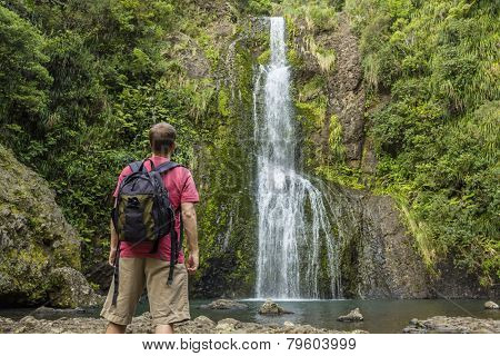 Man looking at scenic waterfall in New Zealand