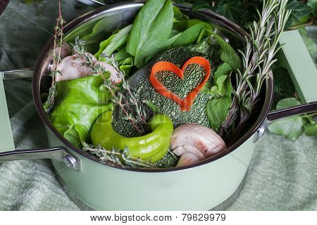 raw vegetables in a saucepan and heart carrots, vegan