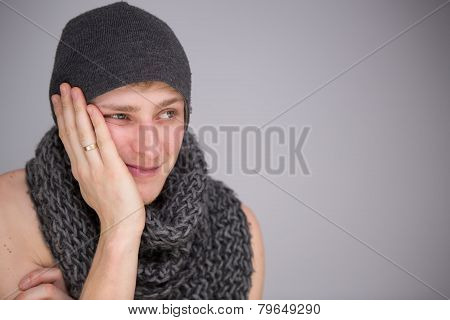 A shirtless man with scarf and hat
