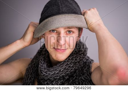 A shirtless man with scarf and hat