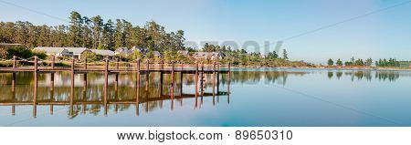 Early Morning Panorama Of Houses Next To A Dam
