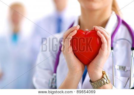 Female doctor with stethoscope holding heart.