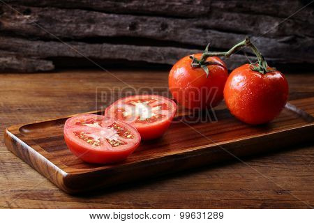 Cool Fresh Tomatoes, Whole And Half On Wooden Tray And Wooden Background