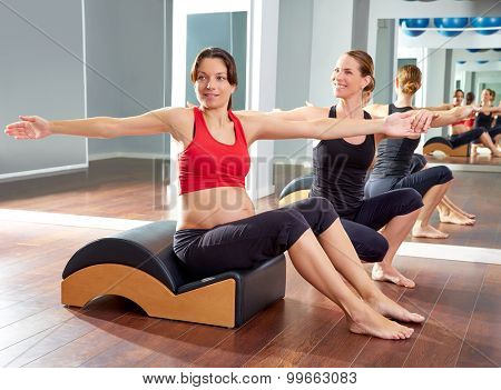 pregnant woman pilates exercise spine twist with Wave corrector and personal trainer