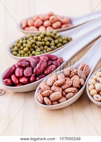 Assortment Of Beans And Lentils In Wooden Spoon On Wooden Background. Mung Bean, Groundnut, Soybean,