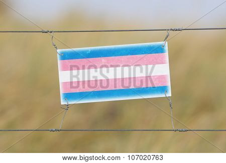 Border Fence - Old Plastic Sign With A Flag