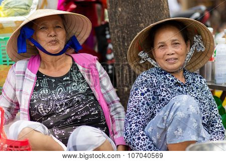 HO CHI MINH VILLE, VIETNAM, FEBRUARY 26, 2015 : Two friendly vegetable sellers are posing in the street of Chinatown in Ho Chi Minh Ville, (Saigon), Vietnam.