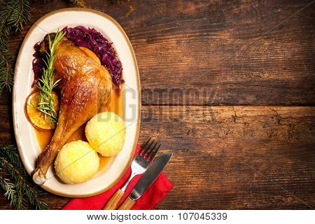 Crusty goose leg with braised red cabbage and dumplings. Cooking at Christmas time