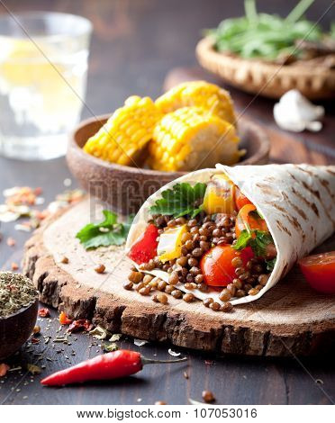 Vegan tortilla wrap, roll with grilled vegetabes, lentil, corn cob.