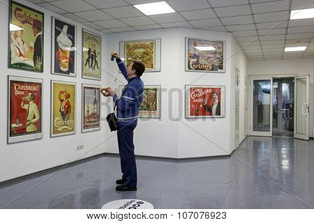 ST. PETERSBURG, RUSSIA - OCTOBER 24, 2015: Tourist making photo of beer posters at the Baltika - St Petersburg brewery during the October Beer Festival. The brewery is providing guided tours to plant