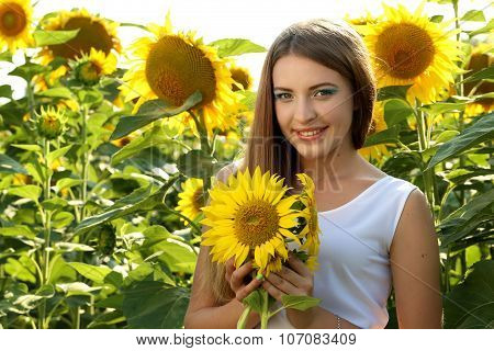 Bea?tiful girl in the sunflowers field