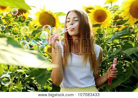 Bea?tiful girl in the sunflowers field
