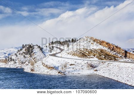 mountain lake, rock cliff, dam and windy road in winter scenery - Horsetooth Reservoir near Fort Collins, Colorado