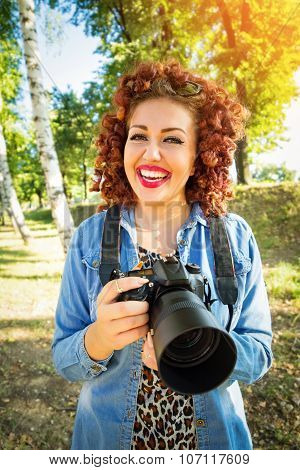 Young female photographer holding digital camera