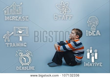 eenage boy frowning sitting on the floor hugging his knees thumb