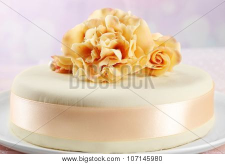 Cake with sugar paste flowers, on light background