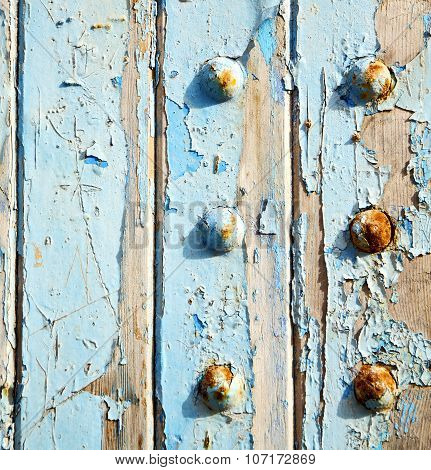Dirty Stripped Paint In The Blue Wood Door And Rusty Nail