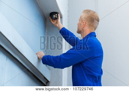 Technician Installing Camera In Corner