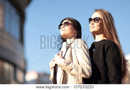 Two Young Beautiful Girls Walking The Streets Of The City.