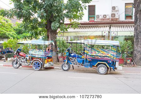 A tuk tuks parked on the side of the main road