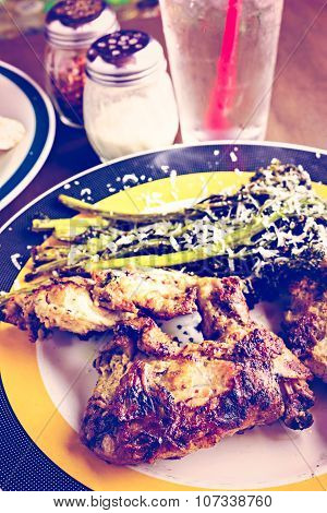 Roasted chicken with broccolini on the plate in Italian restaurant.