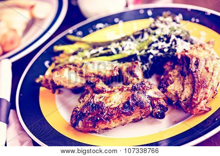 Roasted chicken with broccolini on the plate in Italian restaurant.