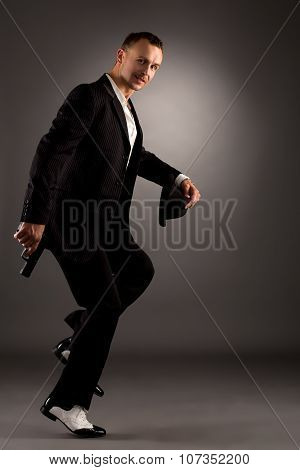 Sexy man in mafiosi costume dancing at camera