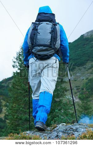 advanture man with backpack hiking on mountain forest