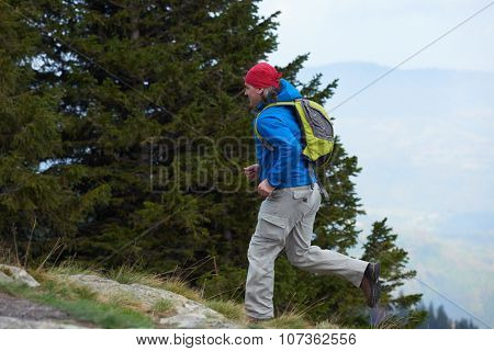 advanture man with backpack hiking on mountain forest