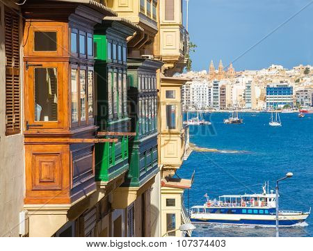 Colorful balconies of Valletta with tourist boat - Malta