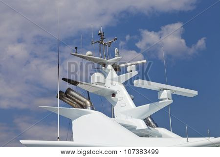 Modern super yacht radar and antennas against clouds background