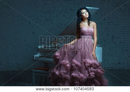 Beautiful Woman Posing Next To A White Piano.