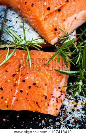 Portions Of Fresh Raw Salmon Fillets With Aromatic Herbs And Olive Oil