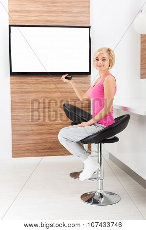 woman smile watching tv rmote control channel