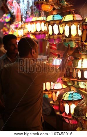 Pune, India - November 7, 2015: A Streetside Shopkeeper Showing Sky Lanterns To A Customer On The Oc