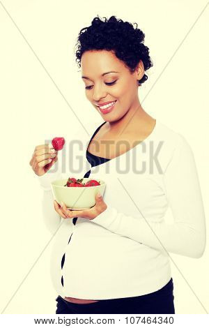 Portrait of a beautifyl young woman eating strawberries.