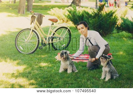 Young Woman With Dogs And Bicycle Having Picnic In The Park