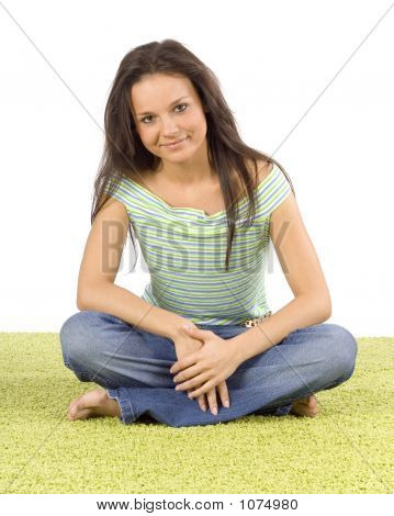 Giovane donna seduta sul tappeto verde