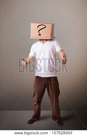 Young man standing and gesturing with a cardboard box on his head with question mark
