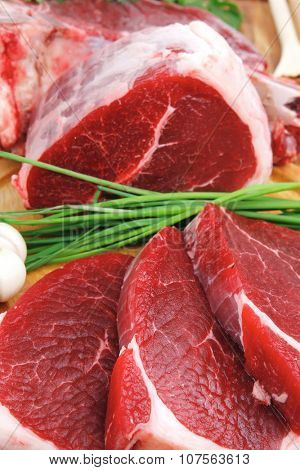 raw meat : fresh beef pork big rib and fillet with garlic and green stuff on wood isolated over white background