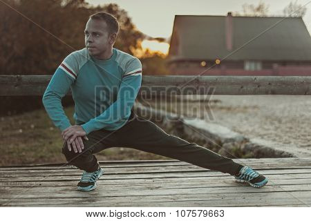 Sport Man Stretching Aoutdoors Doing Exercises Evening At Sunset. Fitness Concepts.