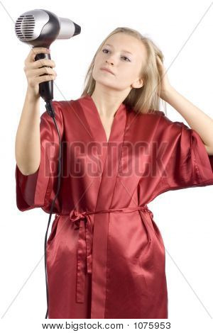 Giovane donna vestita di rosso accappatoio utilizzando i capelli asciugacapelli