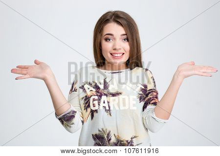 Portrait of a young woman shrugging shoulders isolated on a white background