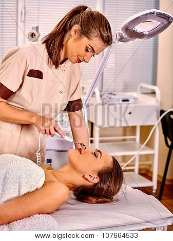 Young woman receiving iontophoresis facial massage  at beauty salon.
