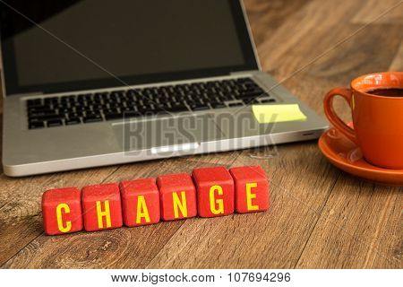 Change written on a wooden cube in a office desk
