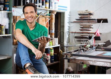 Portrait of confident worker holding digital tablet in paper factory
