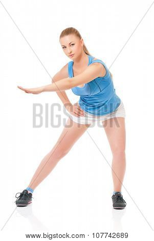 Smiley young sportswoman doing stretching exorcises, isolated on white background