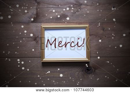 Golden Picture Frame With Merci Means Thank You And Snowflakes